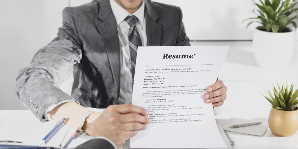 Business professional reviews resume at modern clean desk